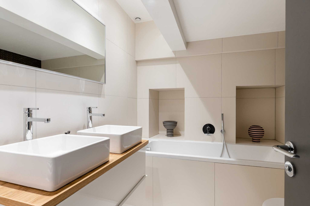 Idée de décoration pour une salle d'eau beige et blanche design avec des portes de placard beiges, un mur beige, un lavabo posé, un plan de toilette blanc, meuble double vasque et meuble-lavabo sur pied.