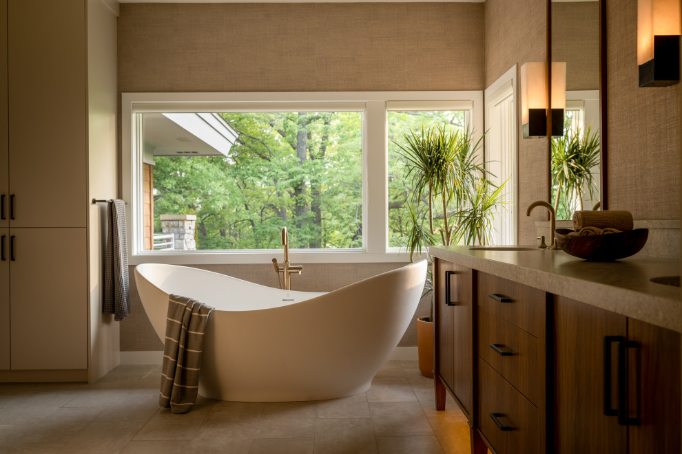 This is an example of a mid-sized contemporary master bathroom in Minneapolis with flat-panel cabinets, a freestanding tub, an undermount sink, granite benchtops, a niche, a double vanity, dark wood cabinets, beige walls, ceramic floors, grey benchtops and a freestanding vanity.