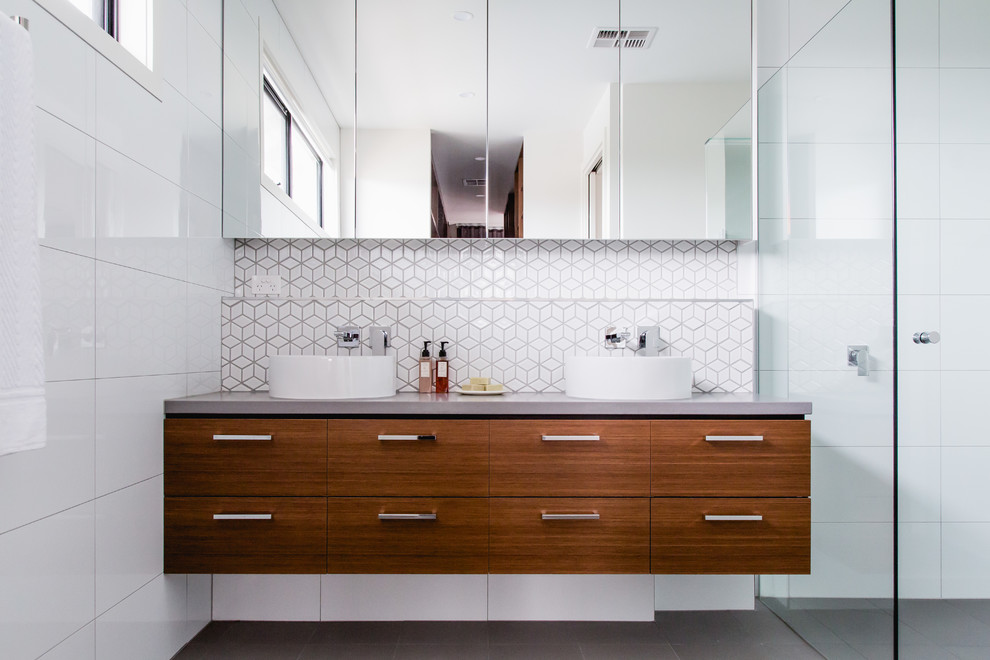 Contemporary bathroom in Melbourne with flat-panel cabinets, medium wood cabinets, white tile, a vessel sink and grey benchtops.