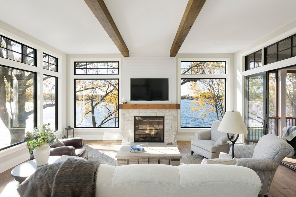 Inspiration for a beach style sunroom in Minneapolis with medium hardwood floors, a standard fireplace, a stone fireplace surround and a standard ceiling.