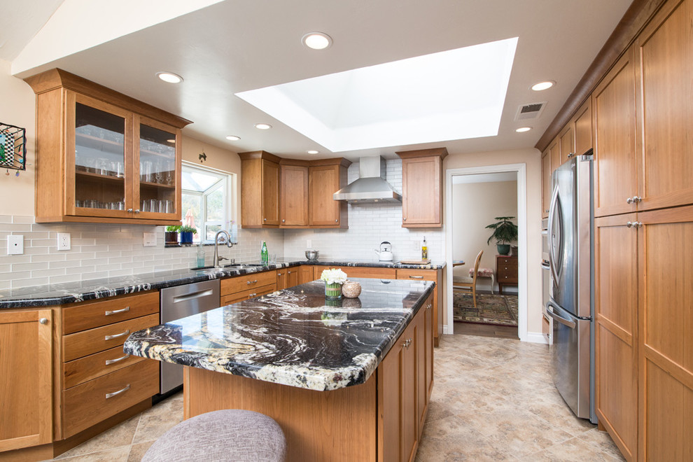 This is an example of a large transitional l-shaped kitchen pantry in San Diego with a drop-in sink, light wood cabinets, granite benchtops, white splashback, ceramic splashback, stainless steel appliances and with island.