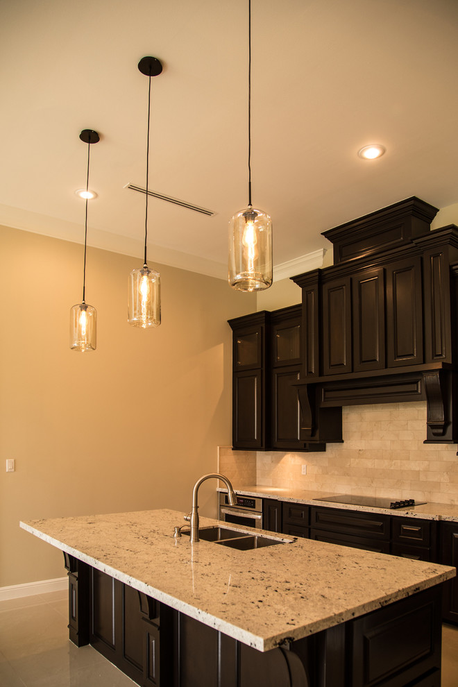 Transitional porcelain tile eat-in kitchen photo in Austin with an undermount sink, raised-panel cabinets, dark wood cabinets, granite countertops, beige backsplash, subway tile backsplash, stainless steel appliances and an island
