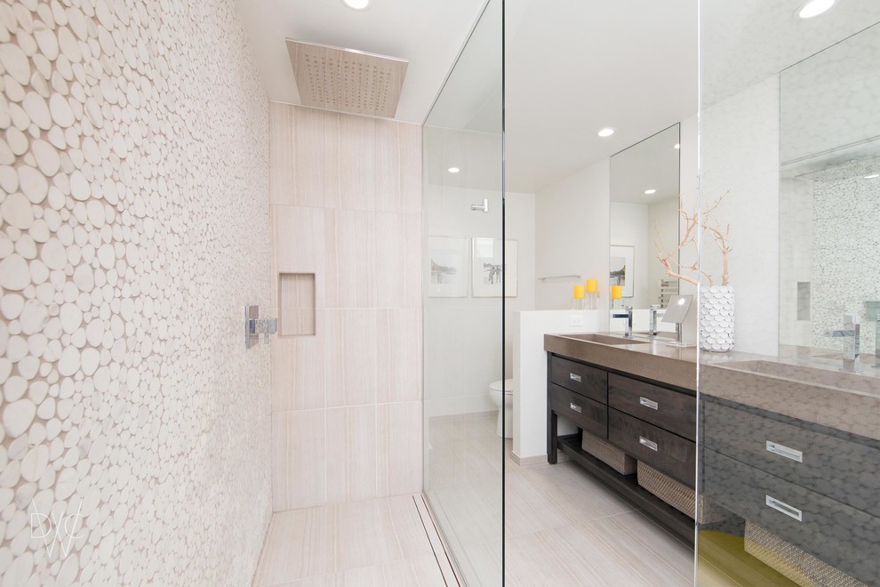 Design ideas for a mid-sized transitional master bathroom in Chicago with flat-panel cabinets, brown cabinets, a curbless shower, a one-piece toilet, beige tile, marble, white walls, ceramic floors, a trough sink, concrete benchtops, beige floor and an open shower.