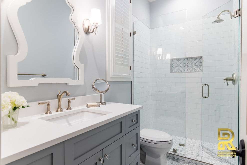Mid-sized transitional subway tile porcelain tile and single-sink bathroom photo in Dallas with shaker cabinets, gray cabinets, gray walls, an undermount sink, quartz countertops, a hinged shower door, white countertops and a built-in vanity
