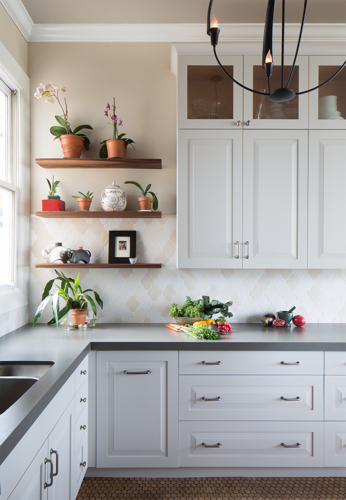 Design ideas for a mid-sized traditional l-shaped kitchen in San Francisco with an undermount sink, white cabinets, quartz benchtops, multi-coloured splashback, ceramic splashback, stainless steel appliances, a peninsula, raised-panel cabinets and porcelain floors.