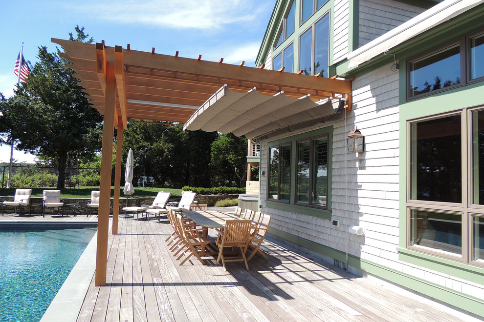 Large beach style backyard deck in Toronto with a pergola.