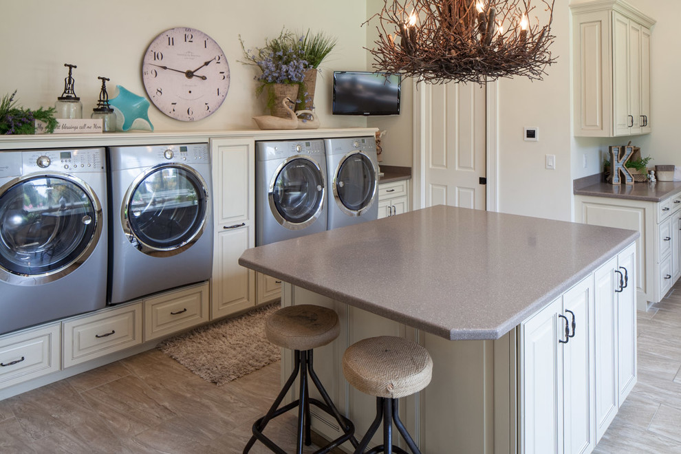 Design ideas for a mid-sized beach style utility room in Other with an undermount sink, raised-panel cabinets, beige cabinets, solid surface benchtops, beige walls, porcelain floors and a side-by-side washer and dryer.