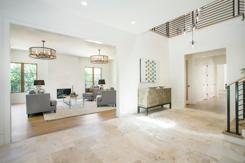 Expansive contemporary entryway in San Francisco with white walls and limestone floors.