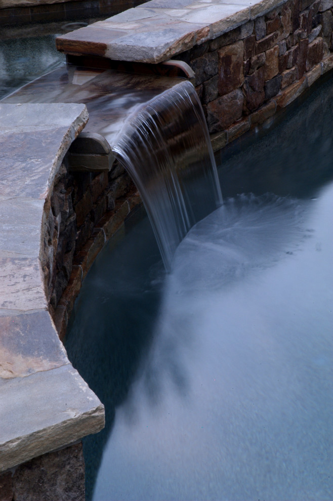 Example of a mid-sized mountain style backyard stone and kidney-shaped hot tub design in Atlanta