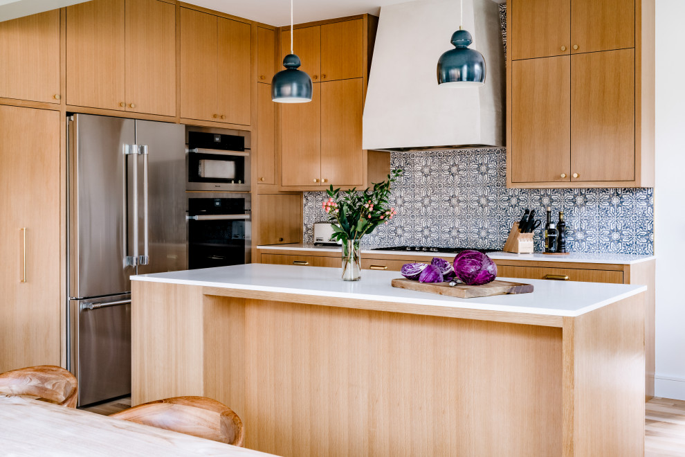 Inspiration for a transitional light wood floor and beige floor open concept kitchen remodel in Austin with flat-panel cabinets, beige cabinets, stainless steel appliances, an island and white countertops