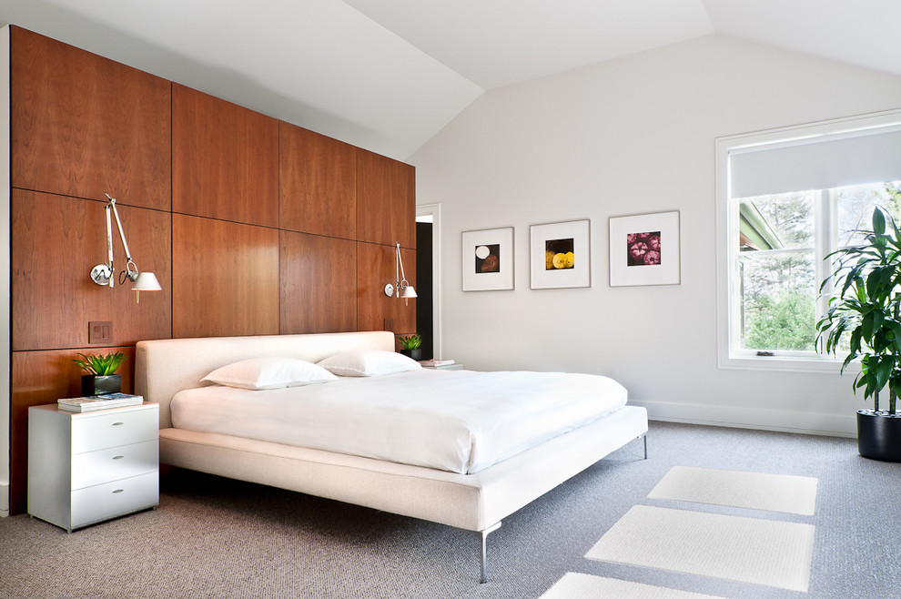 Large contemporary master bedroom in Los Angeles with white walls, carpet and no fireplace.