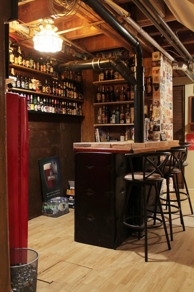 Small industrial seated home bar in Montreal with light hardwood floors.