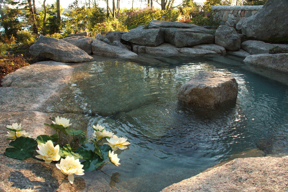 Photo of a mid-sized rustic partial sun backyard stone formal garden.