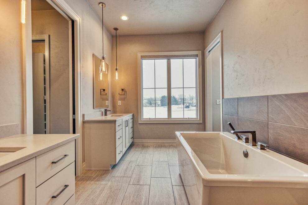 Freestanding bathtub - large transitional master gray tile and ceramic tile ceramic tile and gray floor freestanding bathtub idea with shaker cabinets, white cabinets, an urinal, gray walls, an undermount sink, quartz countertops, a hinged shower door and white countertops