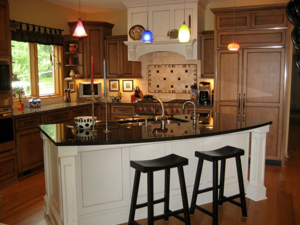 Inspiration for a mid-sized transitional l-shaped dark wood floor open concept kitchen remodel in Milwaukee with a double-bowl sink, recessed-panel cabinets, dark wood cabinets, beige backsplash, stone tile backsplash, stainless steel appliances, an island and granite countertops