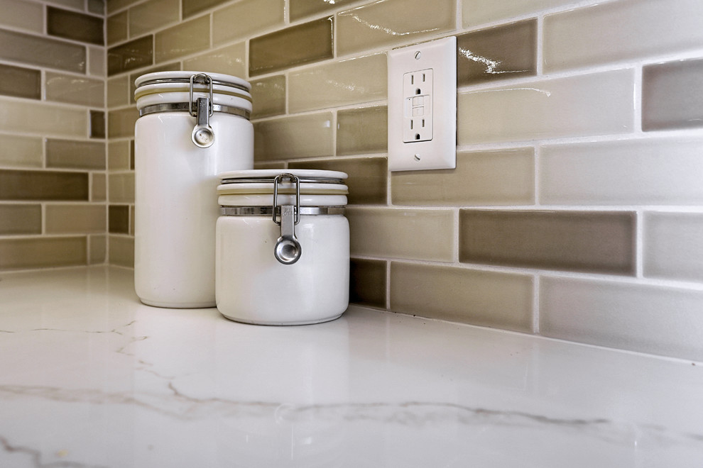 Small transitional ceramic tile and beige floor kitchen photo with a double-bowl sink, shaker cabinets, quartz countertops, beige backsplash, ceramic backsplash, stainless steel appliances and white countertops