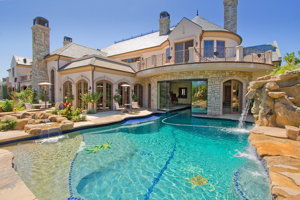 Mediterranean custom-shaped pool in Los Angeles with a water feature.