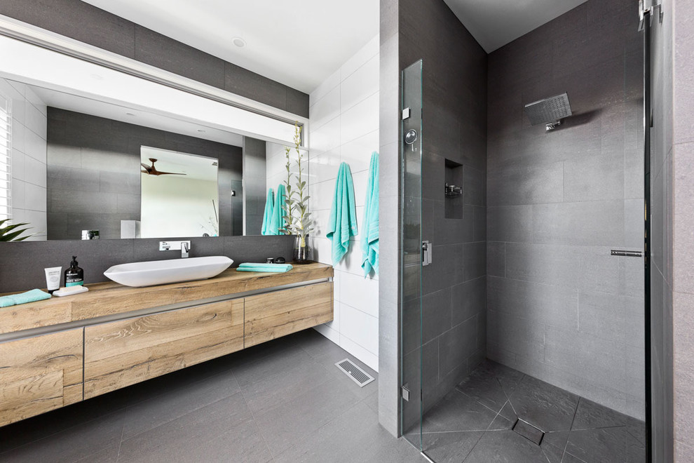 Contemporary 3/4 bathroom in Melbourne with flat-panel cabinets, medium wood cabinets, an alcove shower, grey walls, a vessel sink, wood benchtops, grey floor, a hinged shower door and brown benchtops.