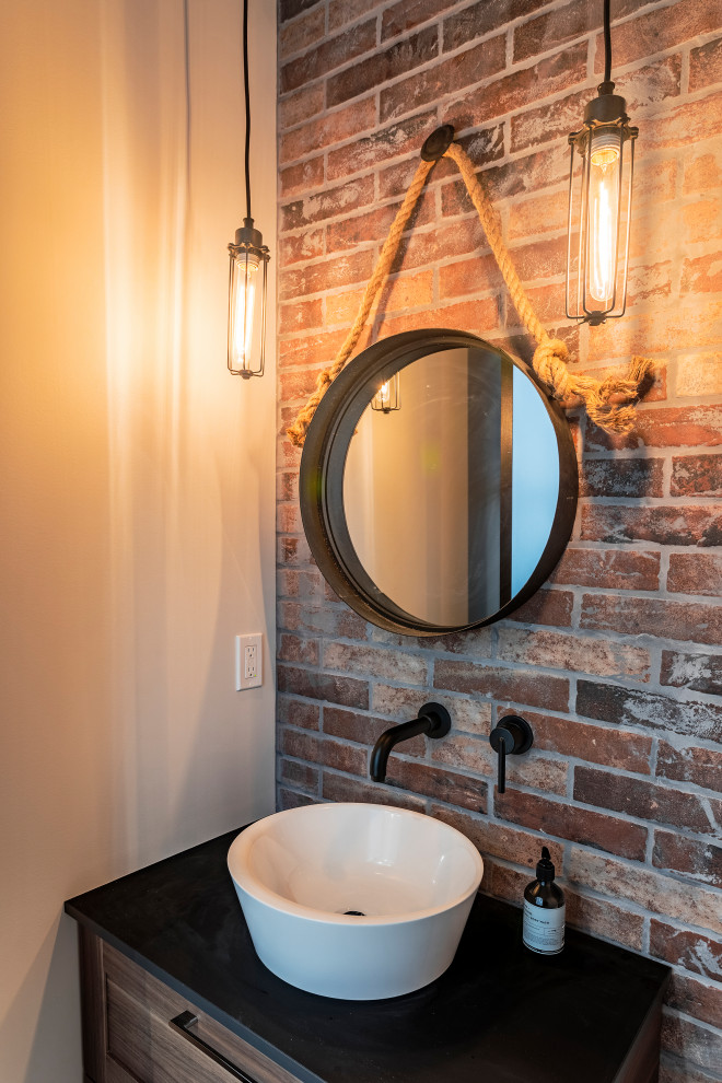 Photo of a mid-sized modern powder room in Vancouver with shaker cabinets, medium wood cabinets, red tile, subway tile, white walls, vinyl floors, a vessel sink, engineered quartz benchtops, brown floor and black benchtops.