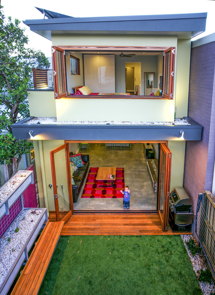 This is an example of a small contemporary two-storey green exterior in Sydney with mixed siding and a flat roof.