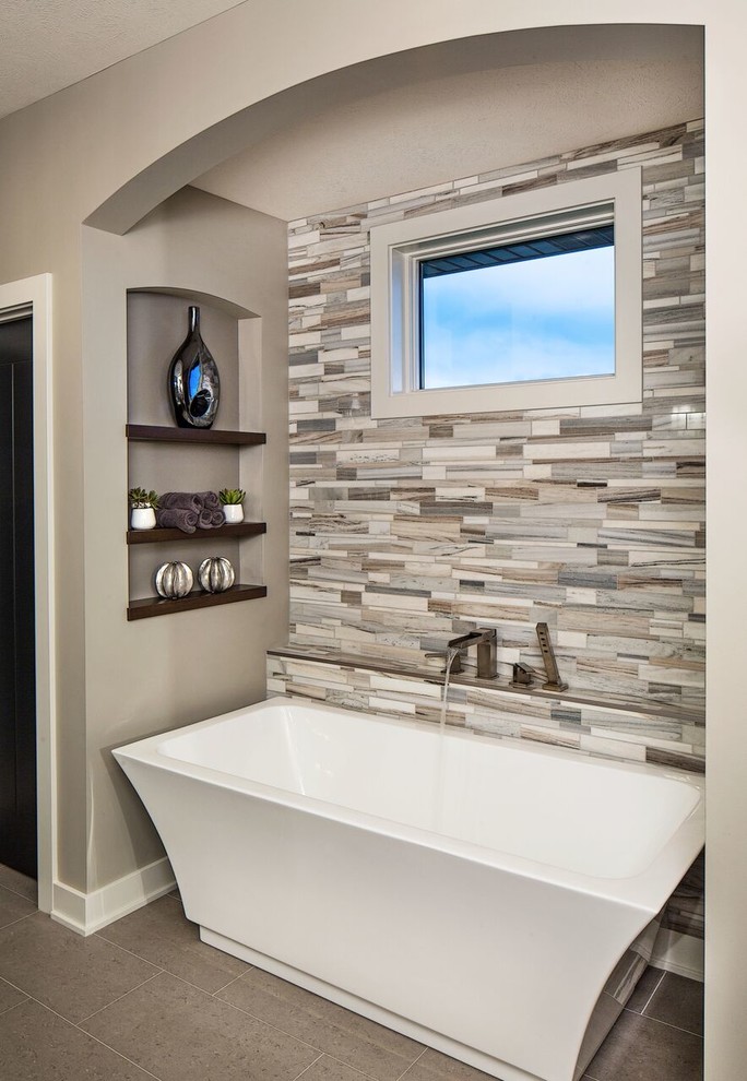 Contemporary master bathroom in Omaha with a freestanding tub, beige tile, gray tile and grey walls.