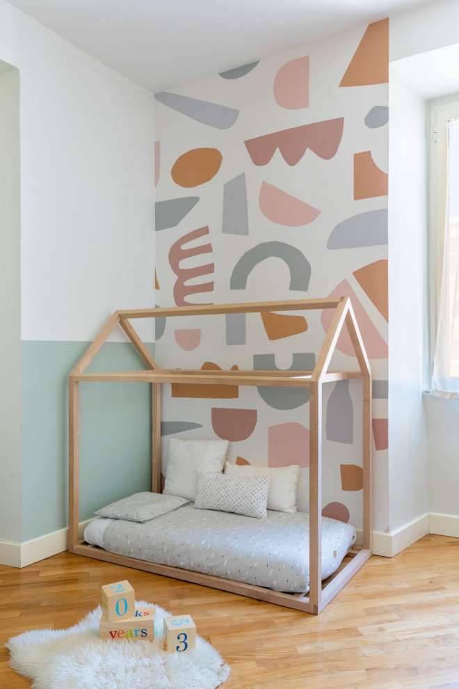 Inspiration for a medium sized scandinavian children’s room for girls in Rome with green walls, medium hardwood flooring, beige floors, all types of ceiling and wallpapered walls.