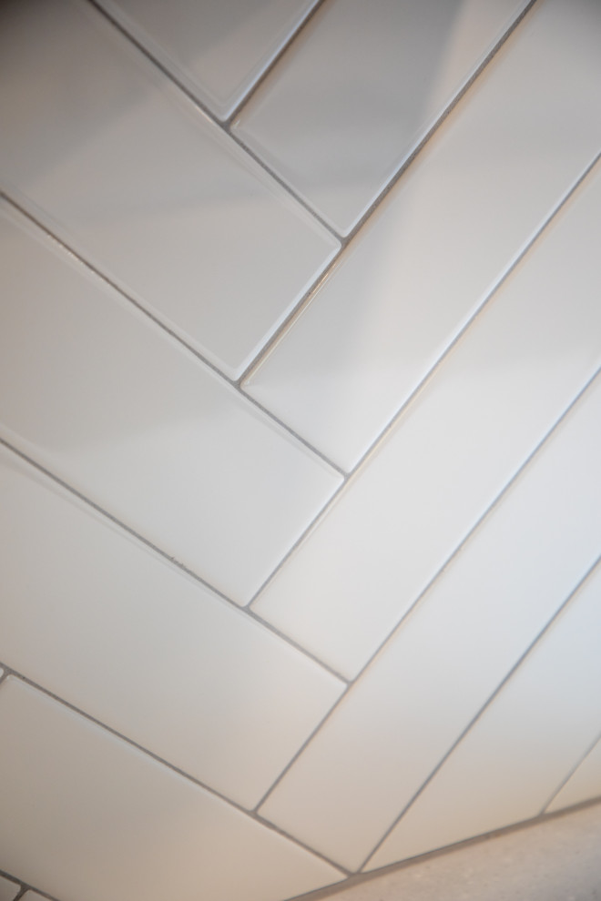 Transitional vinyl floor kitchen photo with shaker cabinets, white cabinets, quartz countertops, white backsplash, porcelain backsplash, stainless steel appliances and white countertops