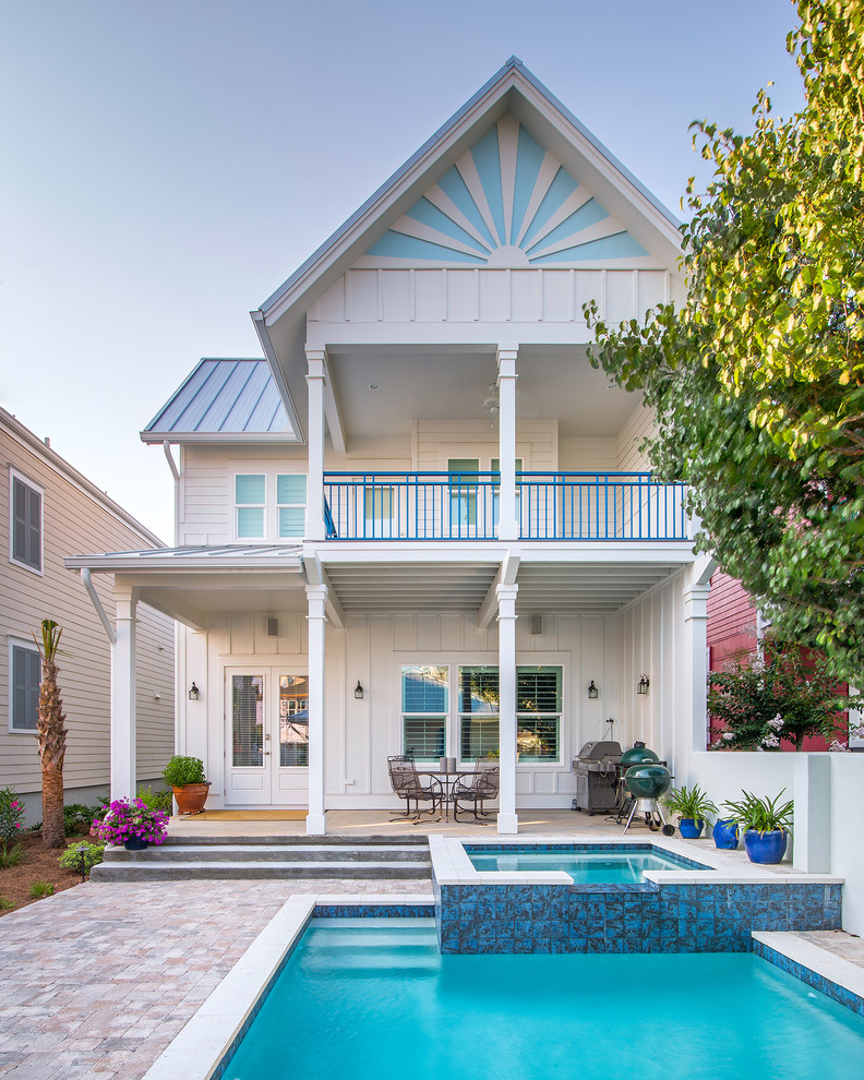 Photo of a mid-sized beach style two-storey white exterior in Atlanta with wood siding and a gable roof.