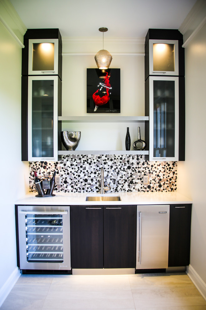 This is an example of a small modern single-wall wet bar in Miami with a drop-in sink, flat-panel cabinets, dark wood cabinets, laminate benchtops, multi-coloured splashback, mosaic tile splashback, white floor and white benchtop.