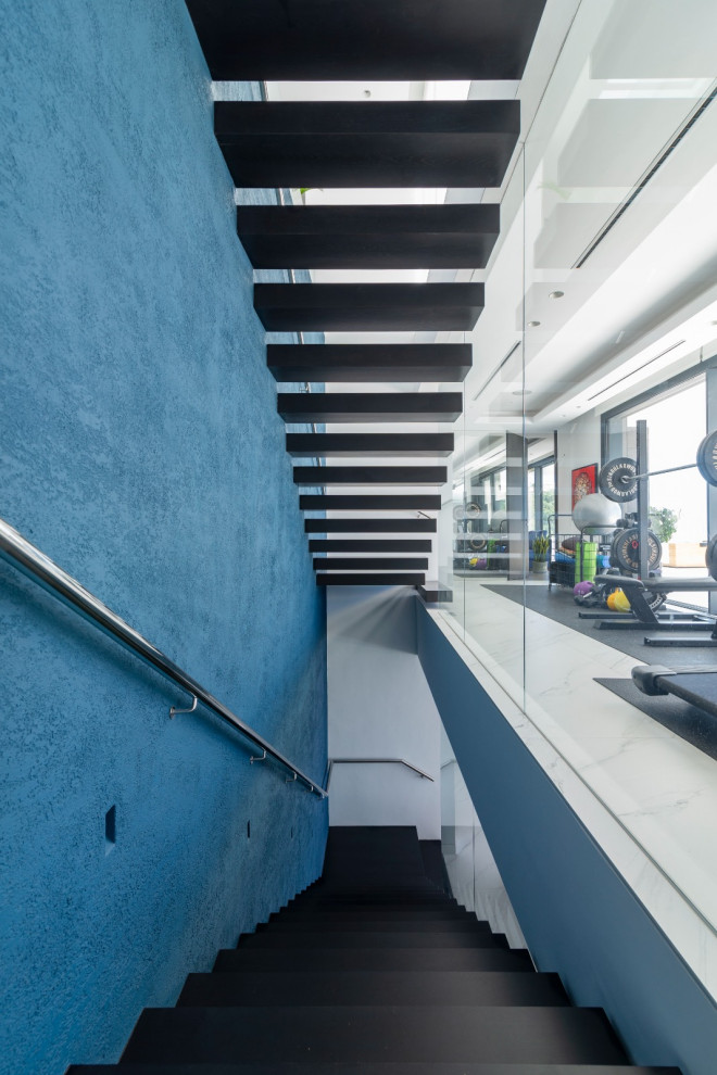 マラガにあるラグジュアリーな広いコンテンポラリースタイルのおしゃれな階段 (ガラスフェンス、全タイプの壁の仕上げ) の写真