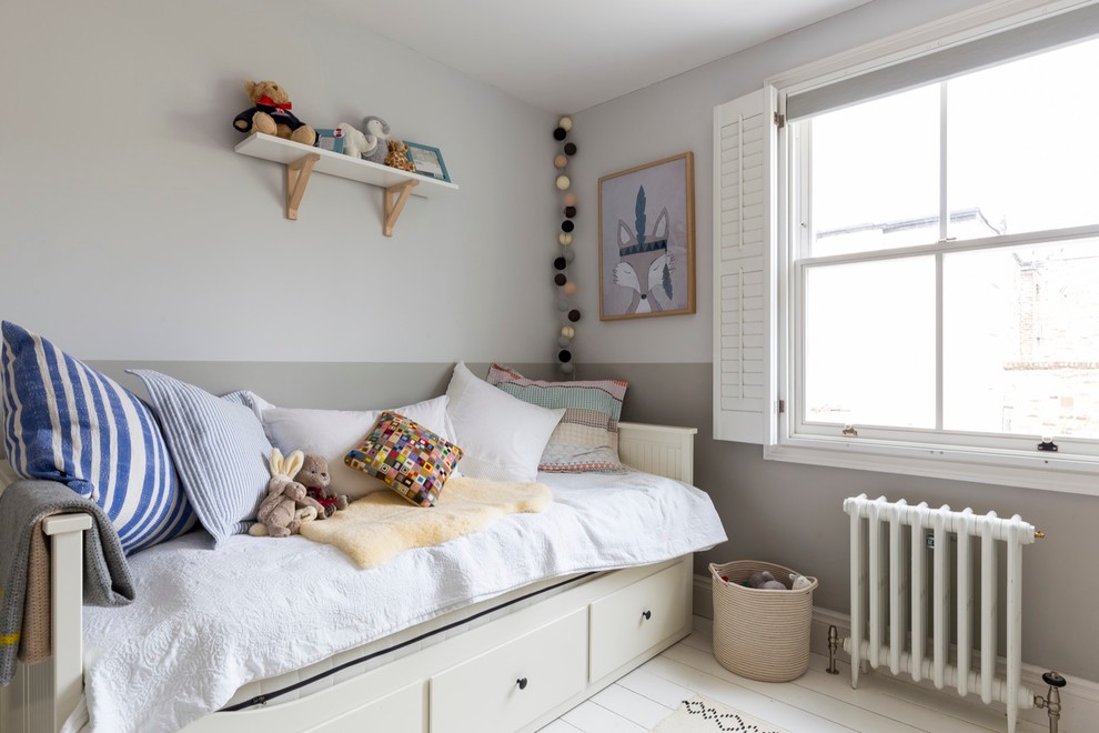 This is an example of a mid-sized transitional kids' room for boys in London with multi-coloured walls and painted wood floors.