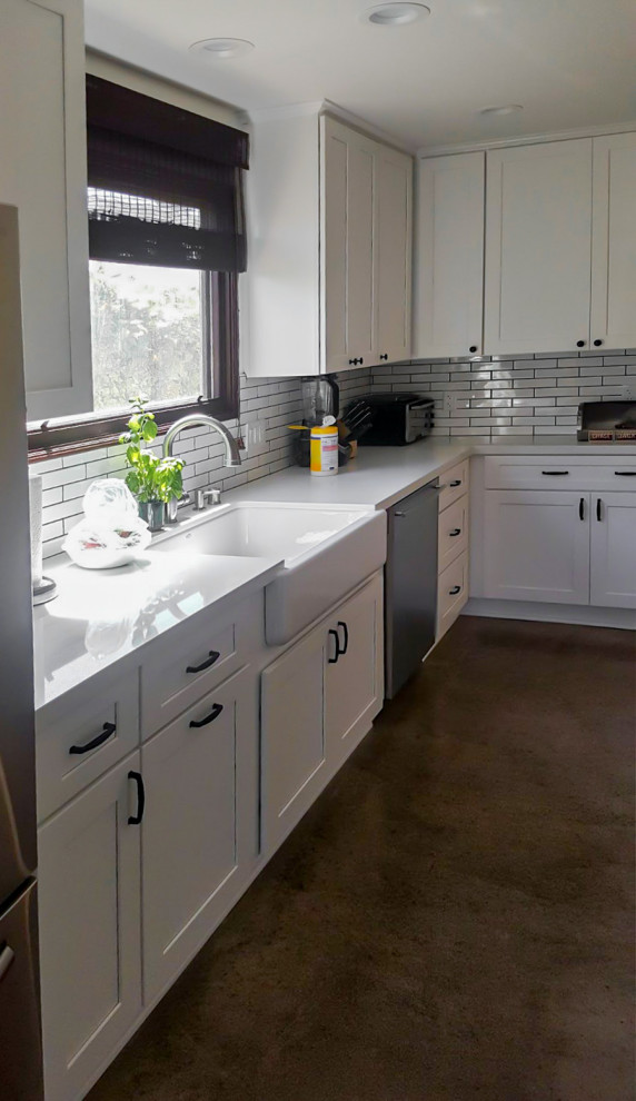 Design ideas for a mid-sized transitional galley kitchen pantry in Los Angeles with a farmhouse sink, shaker cabinets, white cabinets, quartz benchtops, white splashback, subway tile splashback, stainless steel appliances, concrete floors, a peninsula, multi-coloured floor and white benchtop.