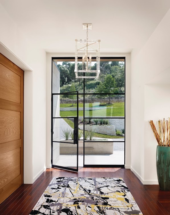 This is an example of a large contemporary foyer in Denver with dark hardwood floors, a single front door, a black front door, brown floor and white walls.