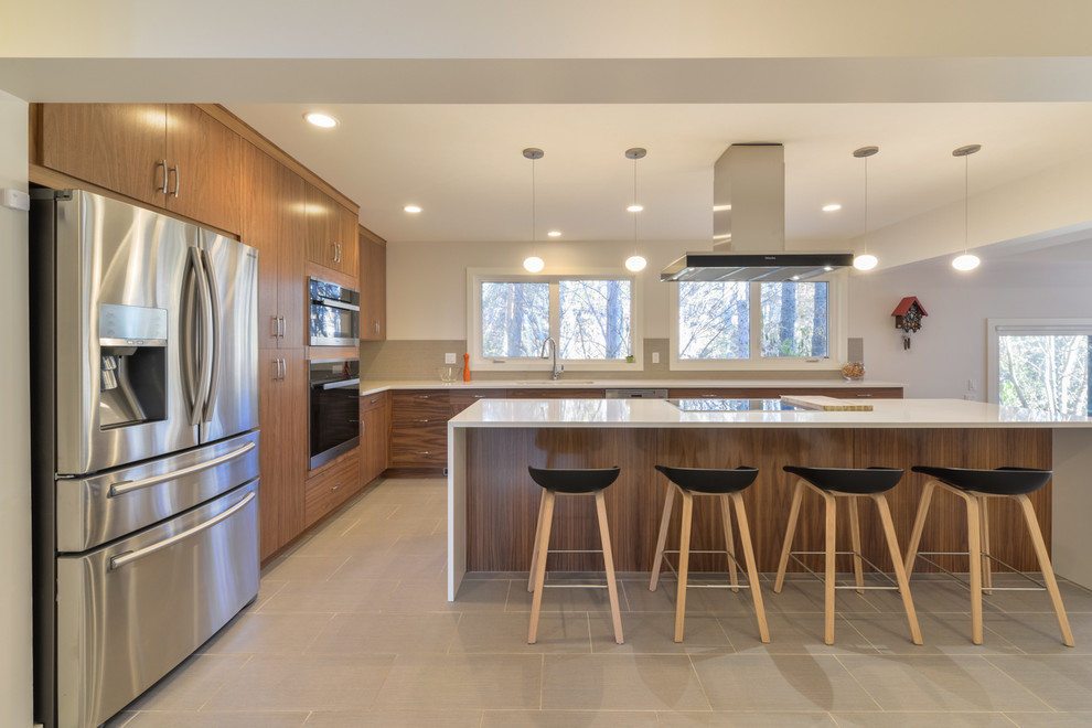 Mid-sized contemporary l-shaped eat-in kitchen in Calgary with an undermount sink, flat-panel cabinets, dark wood cabinets, solid surface benchtops, grey splashback, mosaic tile splashback, stainless steel appliances, porcelain floors, with island and grey floor.