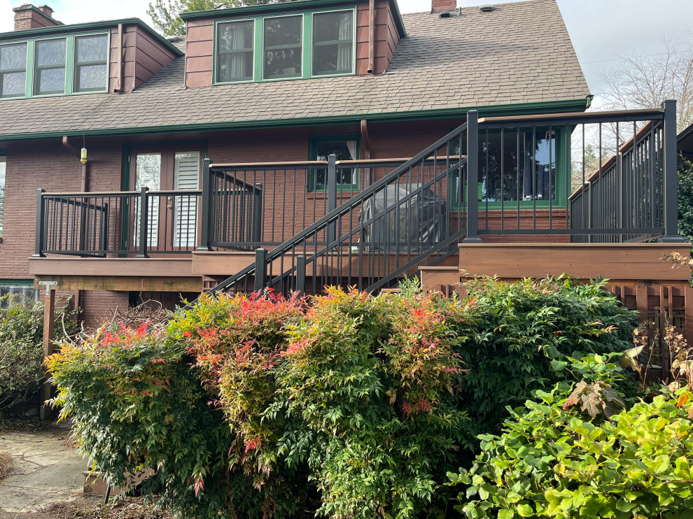 Mid-sized arts and crafts backyard and first floor deck in Seattle with metal railing.