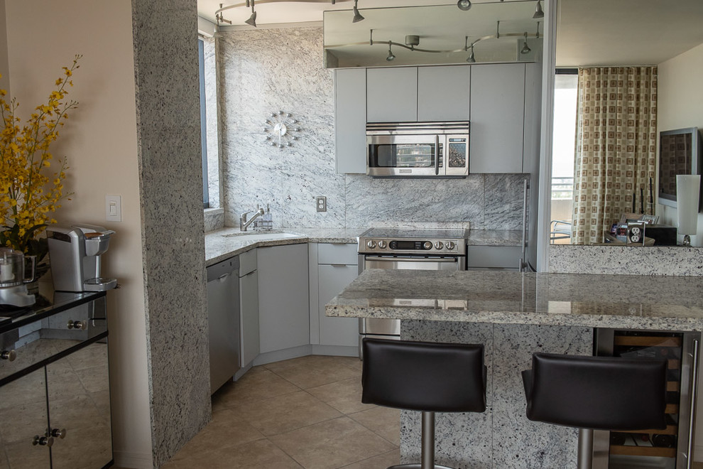 Inspiration for a small modern u-shaped eat-in kitchen in Miami with grey cabinets and stainless steel appliances.