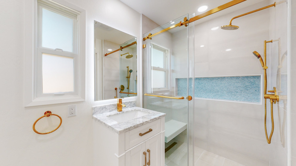 Mediterranean bathroom in San Francisco with white cabinets, a one-piece toilet, ceramic tile, white walls, ceramic floors, marble benchtops, white floor, a sliding shower screen, a single vanity and a built-in vanity.