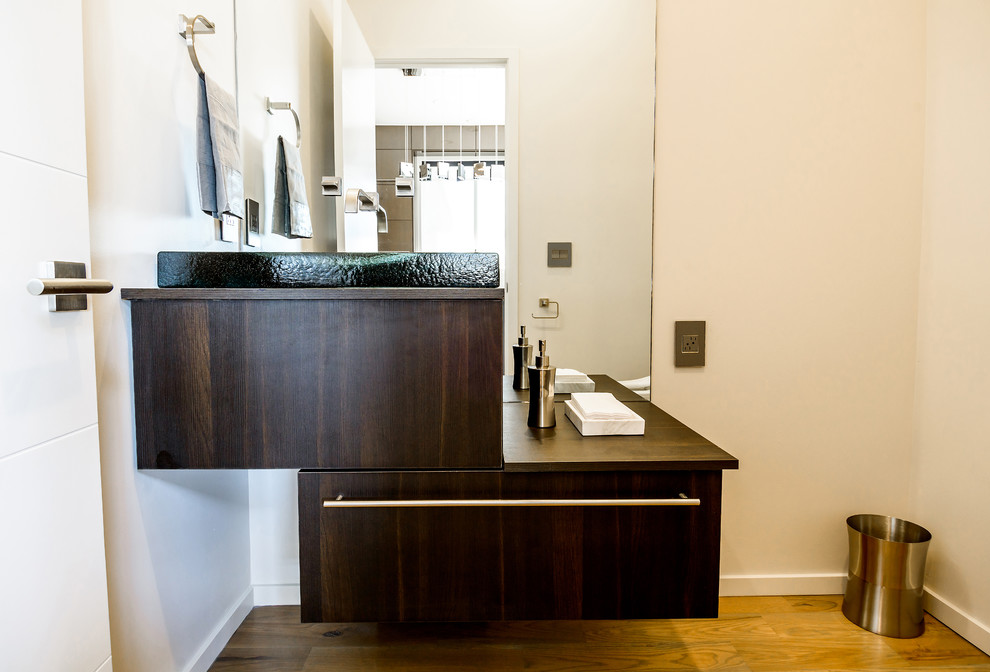 This is an example of a mid-sized contemporary 3/4 bathroom in Oklahoma City with flat-panel cabinets, dark wood cabinets, an undermount tub, a one-piece toilet and white walls.