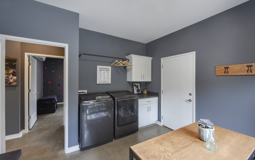 Inspiration for a transitional u-shaped utility room in Other with shaker cabinets, white cabinets, laminate benchtops, grey walls, concrete floors, a side-by-side washer and dryer, grey floor and grey benchtop.