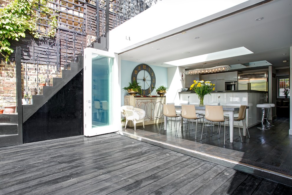 This is an example of a contemporary open plan kitchen in London with dark hardwood flooring.