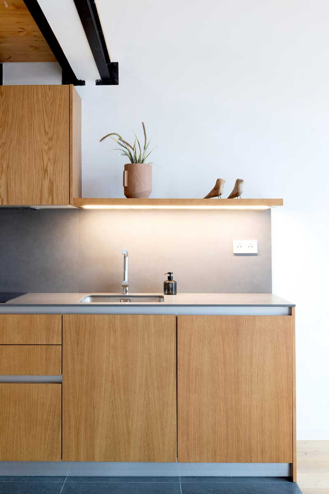 Esempio di una cucina ad ambiente unico moderna con ante lisce, ante in legno scuro e top in acciaio inossidabile