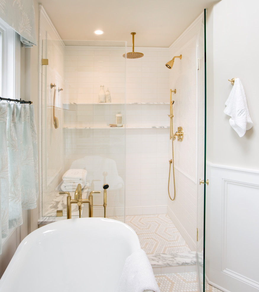 This is an example of a large traditional master bathroom in Philadelphia with recessed-panel cabinets, white cabinets, a freestanding tub, an alcove shower, a two-piece toilet, white tile, ceramic tile, beige walls, marble floors, an undermount sink, marble benchtops, beige floor, a hinged shower door, white benchtops, an enclosed toilet, a double vanity, a built-in vanity, vaulted and decorative wall panelling.