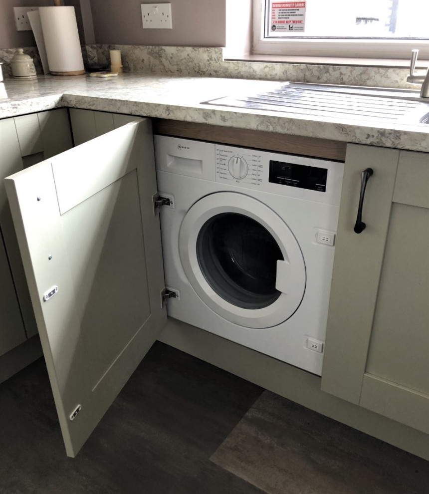 Inspiration for a mid-sized traditional u-shaped laundry room in Other with shaker cabinets, green cabinets, laminate benchtops, brown splashback, glass sheet splashback and brown floor.