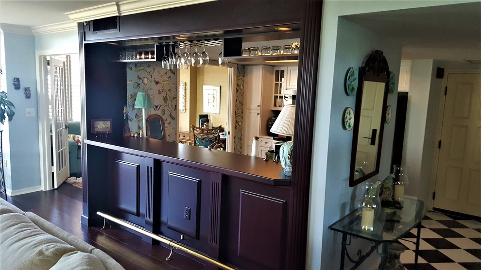 Photo of a mid-sized arts and crafts single-wall seated home bar in Miami with raised-panel cabinets, dark wood cabinets, wood benchtops, dark hardwood floors, brown floor and brown benchtop.