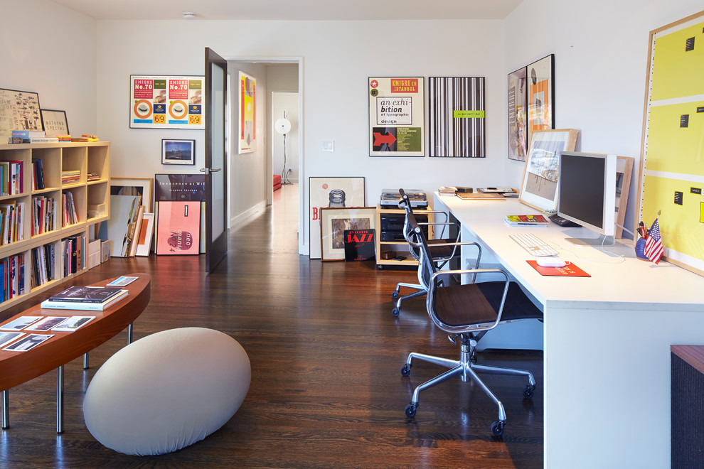 This is an example of a mid-sized contemporary home office in San Francisco with white walls, dark hardwood floors and a freestanding desk.