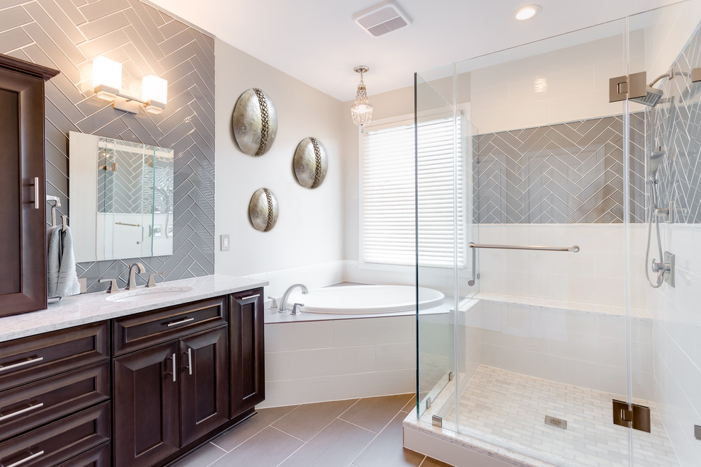 Drop-in bathtub - large transitional master gray tile and glass tile porcelain tile and brown floor drop-in bathtub idea in DC Metro with raised-panel cabinets, dark wood cabinets, beige walls, an undermount sink, quartzite countertops and a hinged shower door