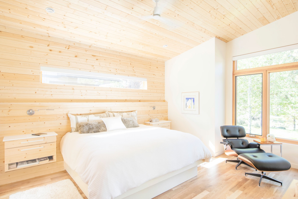 Country bedroom in Other with vaulted, wood and wood walls.