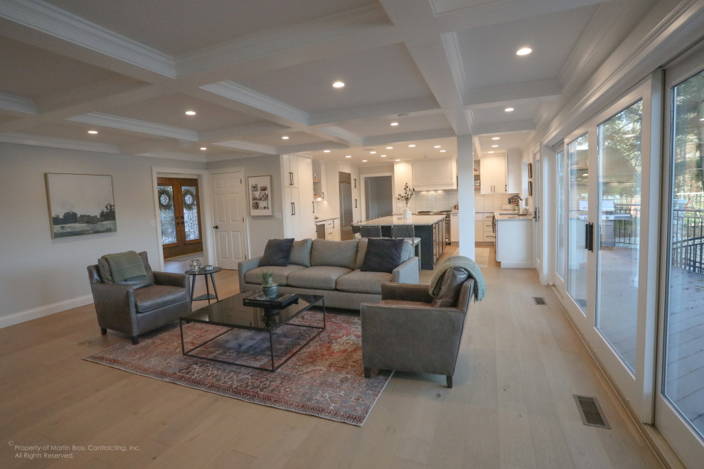 Example of a large transitional u-shaped light wood floor open concept kitchen design with an undermount sink, flat-panel cabinets, white cabinets, quartzite countertops, white backsplash, porcelain backsplash, stainless steel appliances, an island and white countertops