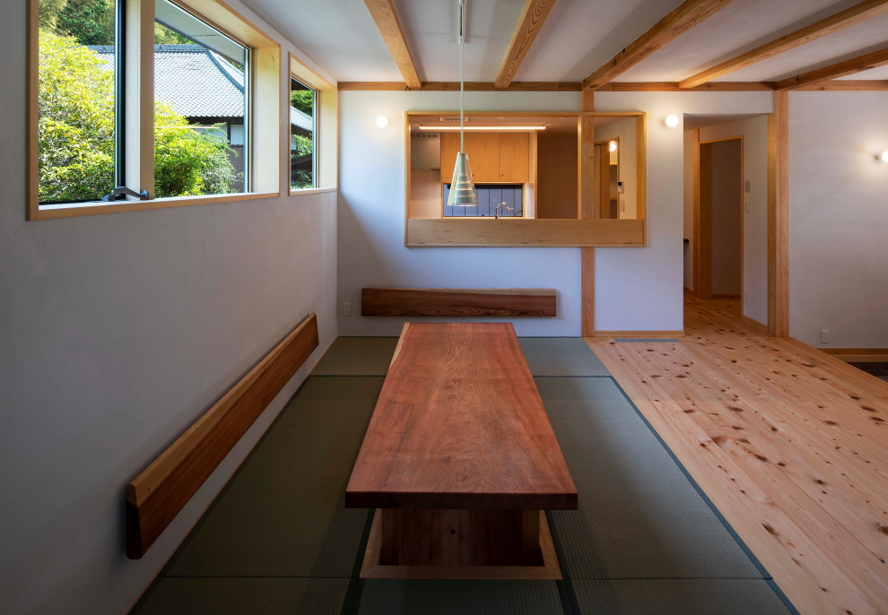 Modelo de comedor blanco tradicional pequeño abierto sin chimenea con paredes blancas, tatami, suelo verde y vigas vistas
