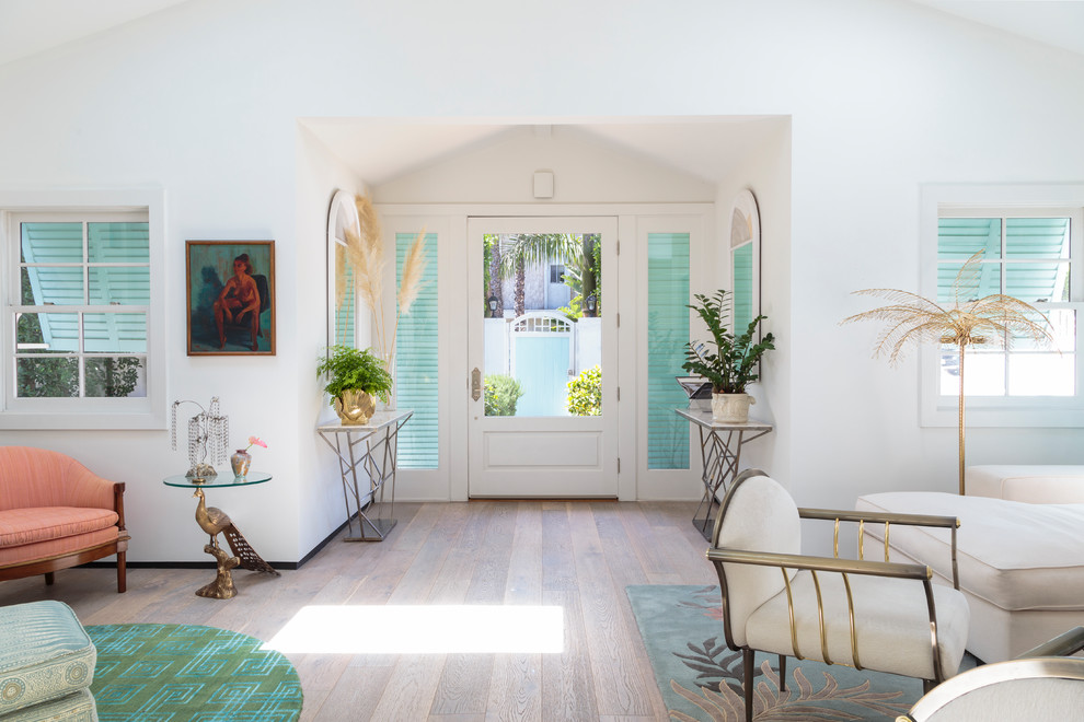 Photo of a beach style foyer in Los Angeles with white walls, light hardwood floors, a single front door, a white front door and beige floor.